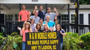 Displaying dealership team standing beside homes